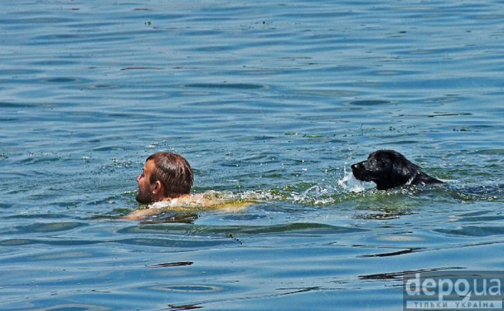 Мужчина плавает с собакой